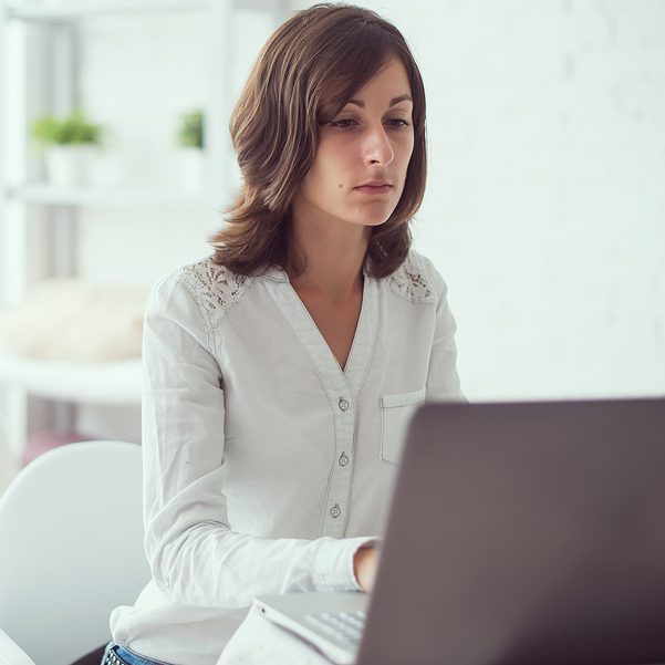 young business woman working at desk typing on a laptop in office young business woman working at desk typing on a laptop in office