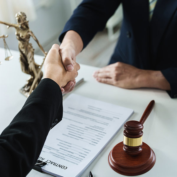 Law, consultation, agreement, contract, lawyer or attorney shakes hands to agree on the clients offer to be hired to fight the parties in court.